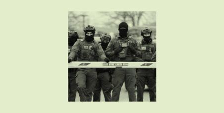 ice agents in masks standing behind a road barrier