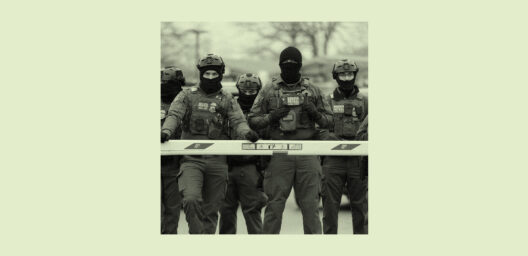 ice agents in masks standing behind a road barrier